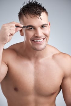Man, portrait and grooming eyebrow hair with tweezer in studio background with body, smile and skincare with hygiene. Wellness, cleanliness and beauty with hands and routine with confidence for face.