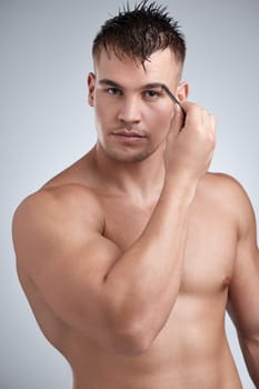Man, portrait and confidence with grooming eyebrow hair with tweezer in studio background for hygiene. Body, cleanliness and beauty with aesthetic, hands and routine for wellbeing with wellness.
