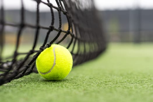 Tennis Ball on the Court against the Court Net. High quality photo