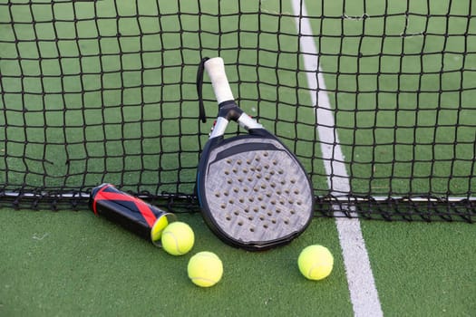 Paddle tennis racket, ball and net on the grass . High quality photo