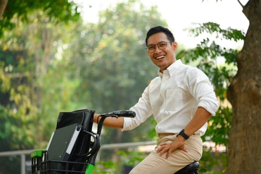 Active businessman commuter traveling to work with electric bicycle in the city.