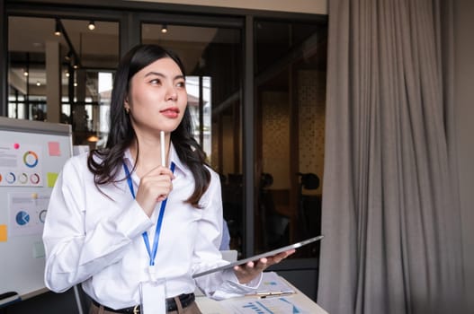 Portrait of a beautiful confident businesswoman standing with a tablet working in her office..