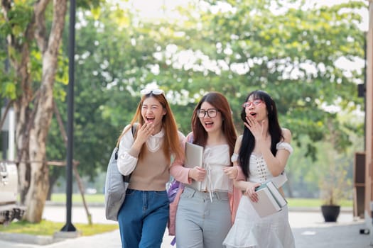 College friends walk to class together. University student in campus talk and have fun outdoors.