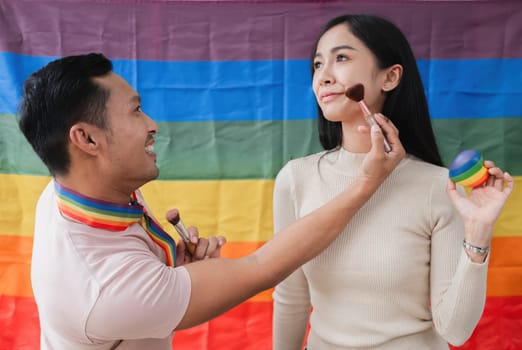 A young gay man and his girlfriend use a laptop and microphone to stream podcast audio at a studio talking about gender liberation..