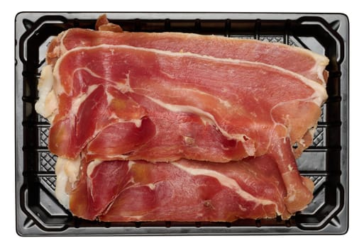 Thinly sliced jamon in a plastic container on an isolated background, top view