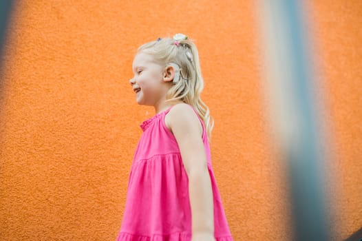 Child with hearing problem and cochlear implant dance in street, deaf kid began to hear. Hearing loss in childhood and treatment concept. Copy space and empty place for text.