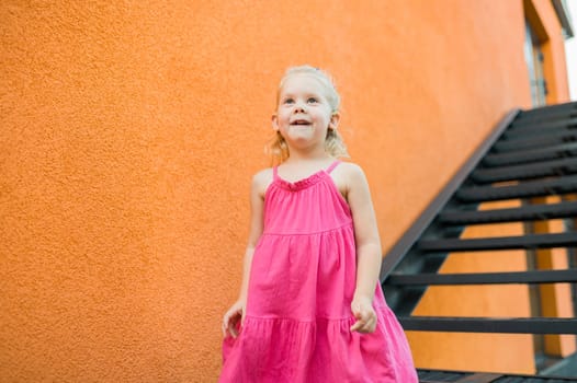 Child with hearing problem and cochlear implant dance in street, deaf kid began to hear. Hearing loss in childhood and treatment concept. Copy space and empty place for text.