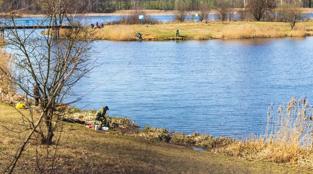 Minsk, Belarus - 03.03.2024 - Fishermen enjoying sunny day by the pond, catching fish