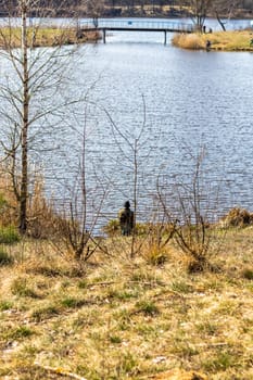 Fishermen enjoying sunny day by the pond, catching fish