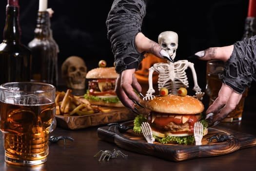The witches hands want to grab the Monster Burger on the sitting skeleton. Perfect Halloween Party appetizer