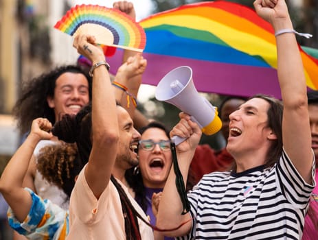 A group of homosexual people excited on a LGBTQ parade jumping and claiming for their rights.