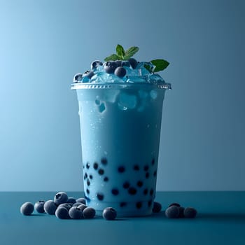 Azure liquid with bubbles and blueberries in a plastic cup on a table, complemented by a drinking straw. Aqua ingredient from a plantbased drinkware