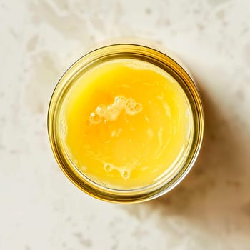 Top view of a jar of ghee on a light background. Healthy diet.
