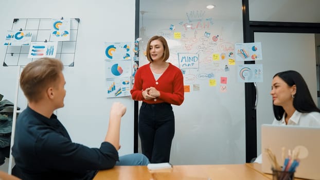 Closeup of young leader present business project with confident by using mind map and colorful sticky notes surrounded by colleague and project manager brainstorming about project. Immaculate.