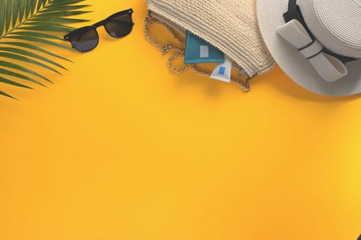 Top view summer travel accessories on yellow background with copy space for your text.