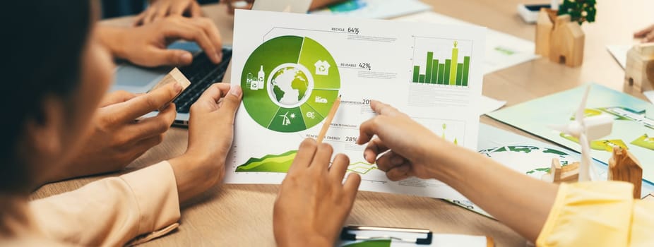 Professional businessman interested in invested in green businesses when he see rising graph on table with environmental document and wooden block scatter around. Closeup. Focus on hand. Delineation.