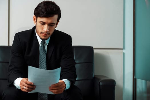 Stressed businessman candidate sit and wait for interview at the company office. Job application, business recruitment and Asian labor hiring concept. uds