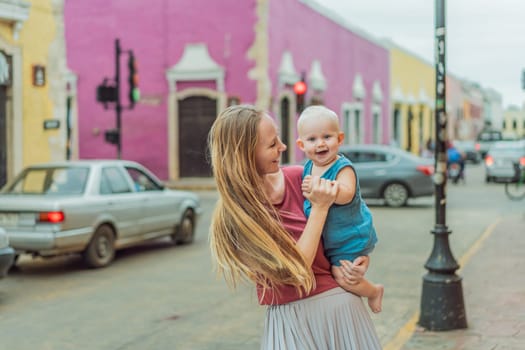 Mother and baby son tourists explore the vibrant streets of Valladolid, Mexico, immersing herself in the rich culture and colorful architecture of this charming colonial town.