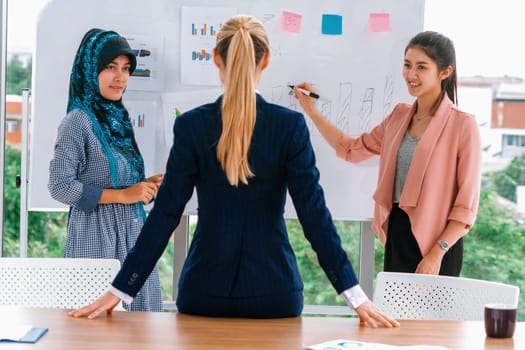 Multicultural working group. Team of businesswomen of different ethnicity, Caucasian, Asian and Arabic working together in team meeting at office. Multiethnic teamwork concept. uds