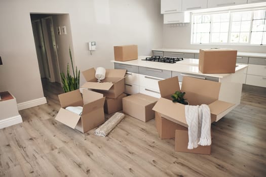 Room, boxes and relocation for moving, apartment and new home with belongings, unpack and no people. Cardboard, mortgage and property for real estate, packaging and kitchen counter in modern house.