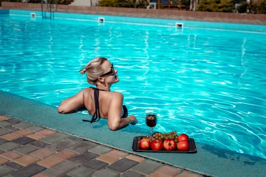Bikini-clad woman enjoys poolside relaxation. Poolside ambiance. Capturing woman's relaxed time near pool