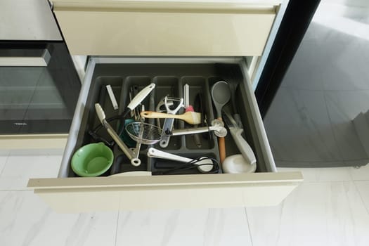 Close up of messy kitchen utensil drawer