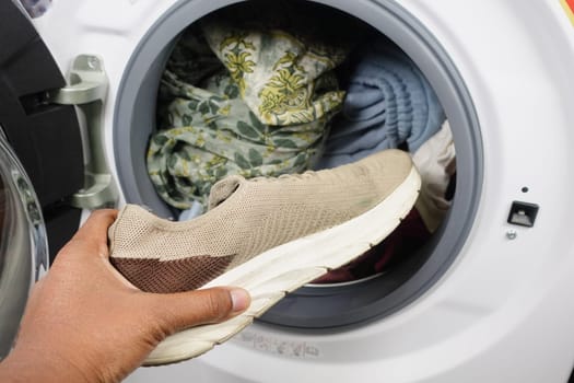 putting dirty shoe in a washing machine..
