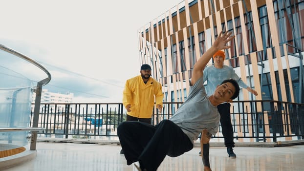 Hip hop team dance break dance while multicultural friend surrounded and clapping hands to cheer or encourage his friend to dance. Active and energetic street dance. Outdoor sport 2024. Endeavor.