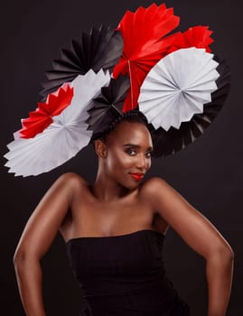 Portrait, African woman and smile with origami on hair in studio background for fashion, art and decor. Female person, designer and glamour for creativity, happy or design with pride or confidence.