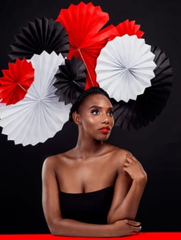 African, female person and origami on hair in dark, studio and background for fashion with style, art and decor. Woman, makeup and glamour for creativity, beauty or design with pride or confidence.