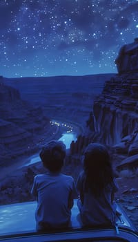 A boy and a girl are perched on the car rooftop gazing at the electric blue sky filled with stars and distant astronomical objects, surrounded by the natural landscape and peaceful atmosphere