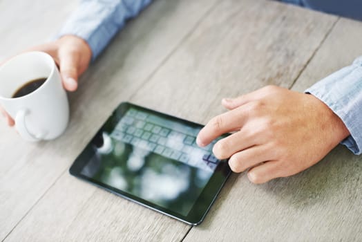 Coffee, table and hand of man with tablet for cryptocurrency, global trading and stock market. Finance, person and trader with tech on desk for investment, planning and news on economy in high angle.