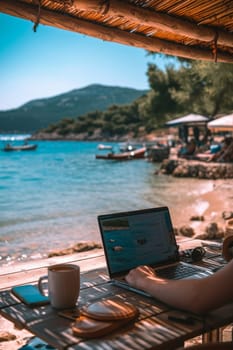 Laptop open on a beachfront table, blending work and leisure with a beautiful coastal backdrop