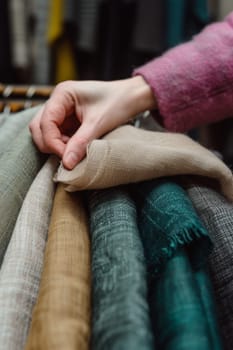 A person in a pink sweater is folding fabric amidst a colorful, cozy setting