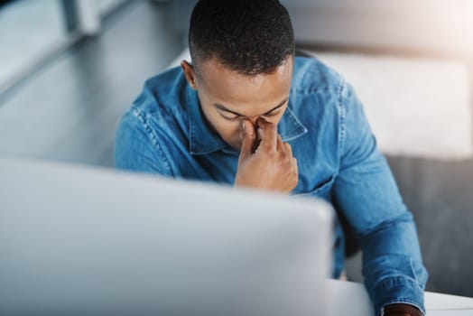 Business, headache and black man in office for anxiety, marketing error or mistake on project. Stress, lens flare and graphic designer at desk for migraine, work crisis or burnout in workplace.