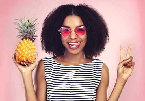 Peace sign, portrait and black woman with pineapple, studio or detox on pink background. Health, nutrition and gut digestion for weight loss and vitamins for female model, vegan and vitamin for fiber.