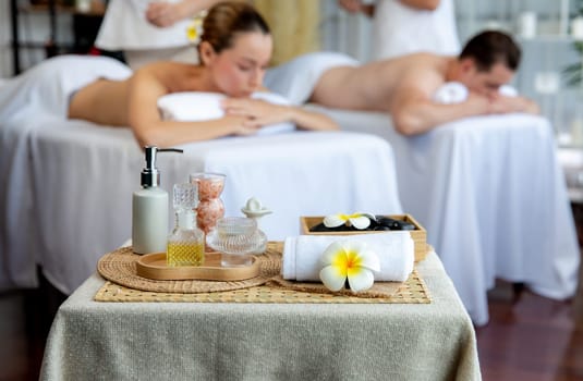 Aromatherapy massage on daylight ambiance or spa salon composition setup with focus decor and spa accessories on blur woman enjoying blissful aroma spa massage in resort or hotel background. Quiescent