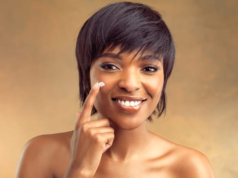 Product, cream and portrait of black woman for beauty, skincare and cosmetics on brown background. Happy, collagen and gen z girl for self care, dermatology and natural shine on studio backdrop.