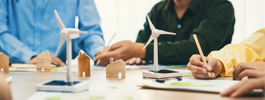 Green business meeting represented renewable energy. Skilled businesspeople discuss green business investment at table with environmental documents. Closeup. Focus on hand. Delineation.