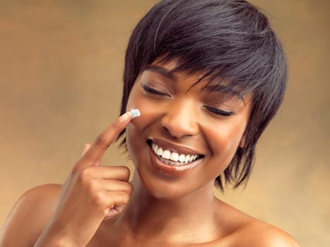 Product, cream and smile of black woman for skincare, beauty and cosmetics on brown background. Happy, aesthetic and face of girl for self care, dermatology and natural shine on studio backdrop.