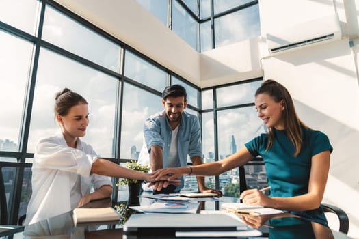 Group of skilled businesspeople putting hands together at modern office.Happy smart business team working together. Represented unity, love, team, working together, partnership, work place. Tracery.