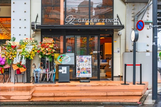 tokyo, japan - apr 25 2024: Entrance of the Tsukasa Hojo 40th anniversary 2025 limited special exhibition "The Road to City Hunter" at the renovated GALLERY ZENON adorned with offered orchid flowers.