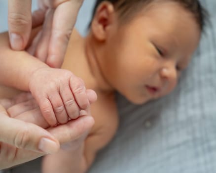 A newborn boy holds his mother's finger. Close-up of hands