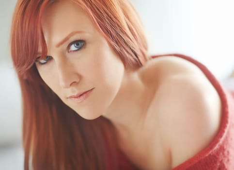 Portrait, sexy and woman with red hair, home and relaxing with peace, confidence and weekend break. Face, person and girl in apartment, sweater and jersey with beauty, ginger and calm in house.