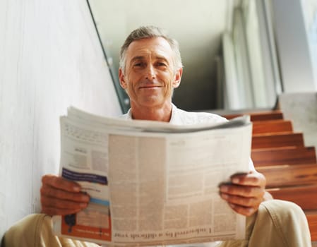 Mature, man and portrait smile with newspaper for journalist report or press information, global or reading. Male person, face and home stairs for feedback review with relax, morning or apartment.