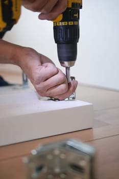 using electric drilling on white wooden board .