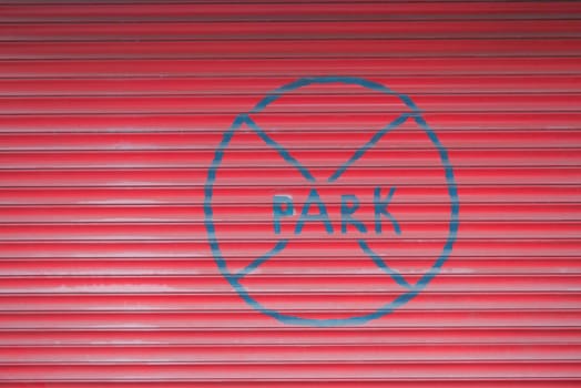 a red garage door with the word no park painted on it.