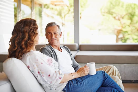 Listen, coffee or mature couple in home living room for conversation or communication in marriage. Peace, drinking tea or woman speaking to man in retirement, house or discussion to relax together.