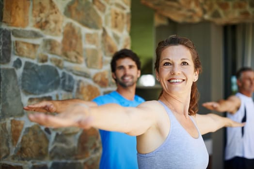 Woman, portrait and warrior pose in yoga class for fitness and mental wellbeing, workout and daily lesson to coach people. Female yogini, posture and yogis or students practice strength and balance