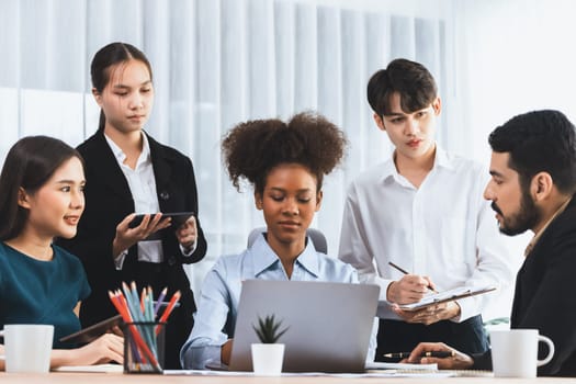 Happy diverse business people work together, discussing in corporate office. Professional and diversity teamwork discuss business plan on desk with laptop. Modern multicultural office worker. Concord